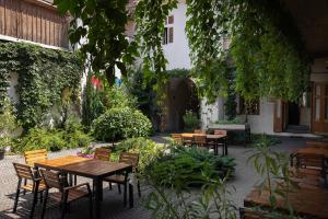 an outdoor patio with tables and chairs and plants at Jules Home in Sibiu