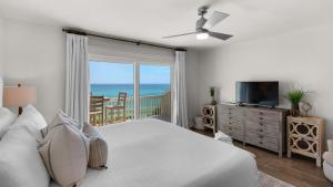 a bedroom with a bed and a television and a balcony at Seashadows Townhomes 4 in Seacrest