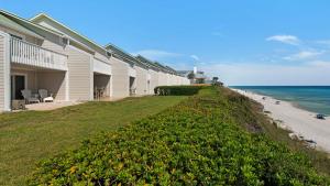 a building on the side of a beach with the ocean at Seashadows Townhomes 4 in Seacrest