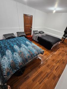 a bedroom with two beds and a wooden floor at Departamento para 4 Personas in Lima
