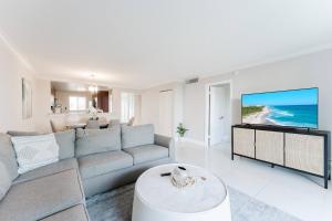 a living room with a couch and a tv at Boca Beach Retreat • Pool • Sand in Boca Raton