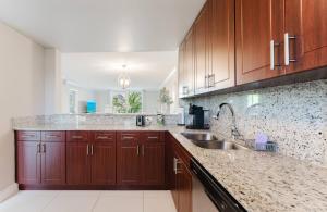 a kitchen with wooden cabinets and a sink at Boca Beach Retreat • Pool • Sand in Boca Raton