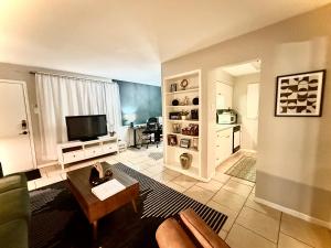 a living room with a couch and a tv at Pristine Full Sized Montrose Apartment Half Block to Menil Museum in Houston