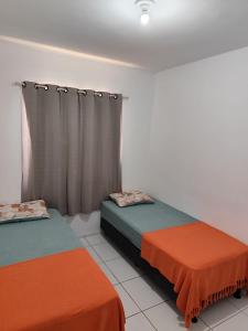 two beds sitting in a room with curtains at Cantinho da harmonia-Morada Nova in Petrolina