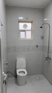 a white bathroom with a toilet and a window at أجاويد 3 Ajaweed in Salalah +8 photos
