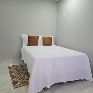 a bedroom with a bed with white sheets and pillows at Suite Harmonia in Alto Paraíso de Goiás +8 photos