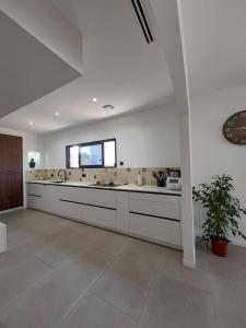 AucamvilleにあるThefamilyHouse - 8pers - clim - parkingの広いキッチン(白いカウンター、シンク付)