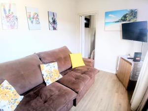 a brown leather couch in a living room at Frente ao Mar Residence in São Vicente