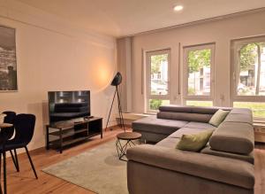 a living room with a couch and a flat screen tv at HappySide Karli Loft 1- Parkplatz - WLAN - SmartTV in Leipzig