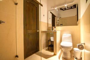 a bathroom with a toilet and a glass door at Casa familiar con jacuzzi y vista increíble in Villa de Leyva +26 photos