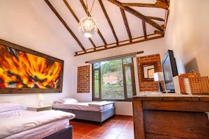a room with two beds and a tv and a window at Casa familiar con jacuzzi y vista increíble in Villa de Leyva
