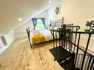 a bedroom with a bed and a window and a staircase at Coach House Studio, quiet, rural, pet friendly, Probus in Probus