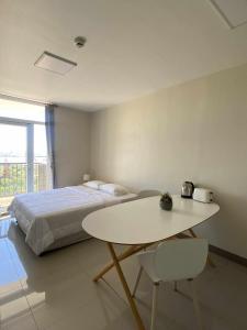 a bedroom with a bed and a table and chair at Cheap Accommodation - Saekyung Apartments in Suba