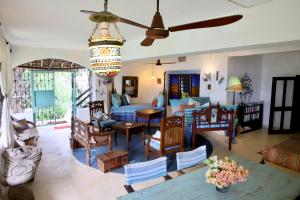 a living room with a bed and a dining room at Self catering Beach House on award winning marine conservancy in Kijangwani