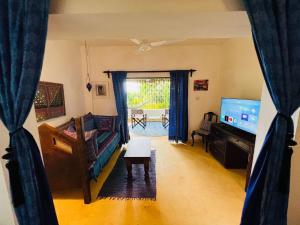 a living room with a couch and a table at Self catering Beach House on award winning marine conservancy in Kijangwani