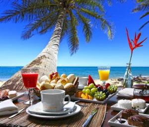 - une table avec un plateau de nourriture et de boissons sur la plage dans l'établissement Sands Inn Hotel, à Pwani Mchangani