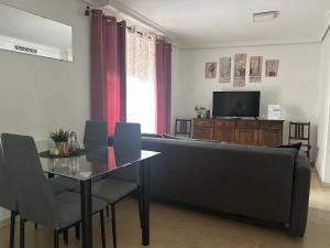 a living room with a table and a couch and a television at Corredera Cordoba in Córdoba
