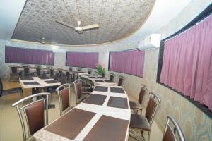 a dining room with tables and chairs and a ceiling at Kings Executive and Restaurant in Tuljapur