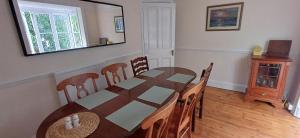 a dining room with a table and chairs and a mirror at Brookside Lodge, central Dawlish in Dawlish