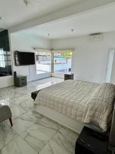 a bedroom with a bed and a flat screen tv at Casa Girasol in Oaxtepec +23 photos