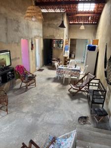 a living room with chairs and a tv and a table at Casa de Praia em Abaís in Estância