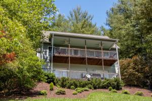 a house with a balcony and trees at 3 Bed Cabin Overlooking the New River-- HOT TUB, Fire Pit, Dogs OK in Obids