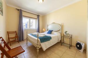 une chambre avec un lit, une chaise et une fenêtre dans l'établissement Portimão Central Apartment, à Portimão