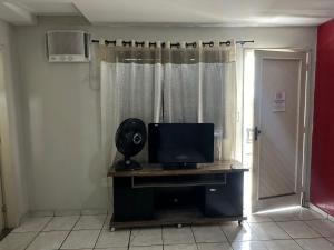 a room with a television on a desk with a window at Hotel Paradão Linhares in Linhares