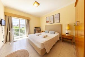 a bedroom with a bed and a large window at Quintão Apartment in Portimão in Portimão +43 photos
