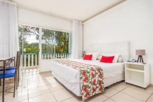 a bedroom with a bed and a balcony at Hotel Miratlantico Búzios in Búzios