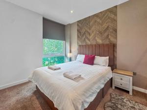 Un dormitorio con una cama grande con dos toallas encima. en Marvel House, en Milton Keynes