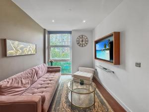 Una sala de estar con un sofá y un televisor en Marvel House, en Milton Keynes