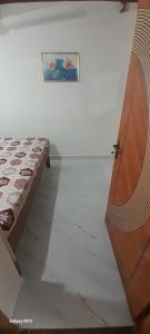 a bedroom with a bed and a painting on the wall at Mahadev Residency in Tiruvannāmalai