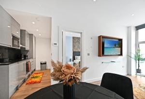 cocina y sala de estar con mesa y TV en Marvel House, en Milton Keynes