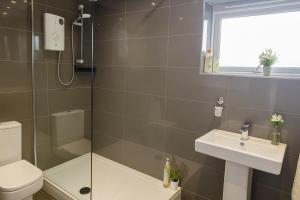 a bathroom with a shower and a sink and a toilet at Cosy 3 Bed House, Decked Garden, Free Parking in Central Station