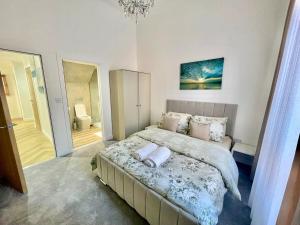 a bedroom with a large bed with a chandelier at Three bedroom Apartment In Glasgow City Centre in Glasgow +24 photos