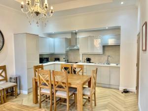 a kitchen with a wooden table and chairs at Three bedroom Apartment In Glasgow City Centre in Glasgow