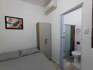 Schlafzimmer mit einem Bett, einem WC und einem Spiegel in der Unterkunft Um paraíso no fim da rua in Barra de São Miguel
