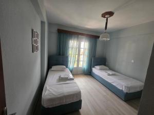 a room with two beds and a window at Chrysalis Apartment in Nea Potidaea