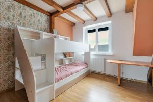 ein Schlafzimmer mit Etagenbett und Schreibtisch in der Unterkunft Maison Le Nid de Cigognes in Witternheim