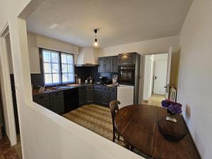 PriziacにあるMaison de campagne - 8 personnes - 3 nuits minimumの木製のテーブルとダイニングルームのあるキッチン