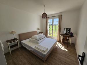 PriziacにあるMaison de campagne - 8 personnes - 3 nuits minimumのベッドと窓のある白い寝室