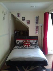 1 dormitorio con 1 cama con banderas británicas en la pared en Brookside Lodge, central Dawlish, en Dawlish 5 fotos más
