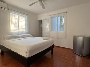a bedroom with a large bed with a fan and two windows at Casa Balam Cayo Lobo in Cancún +43 photos
