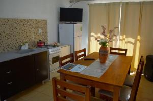 a kitchen with a wooden table with a vase of flowers on it at Hospedaje Martina in Belén