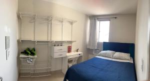 a small bedroom with a blue bed and a desk at Apartamento Amplo in Natal