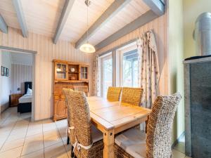 een eetkamer met een houten tafel en stoelen bij Ferienhaus im Ferienpark Mirow in Granzow