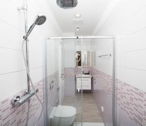a bathroom with a glass shower with a toilet at Boutique Hotel Melissa in Poreč