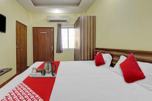 a bedroom with a large bed with red pillows at Hotel O Maheshwari Residency in Rānchī +15 photos
