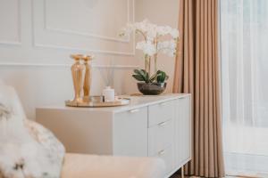 a white dresser with vases and flowers on it at Modern town house in Ramsgate